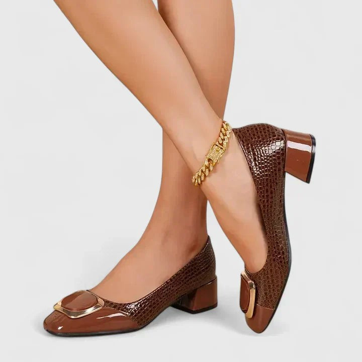 Brown croc-embossed block heel loafers paired with a gold chain anklet