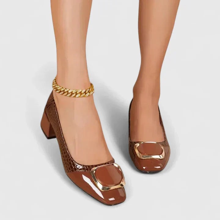 Front view of brown croc-print block heel pumps with gold buckle accent