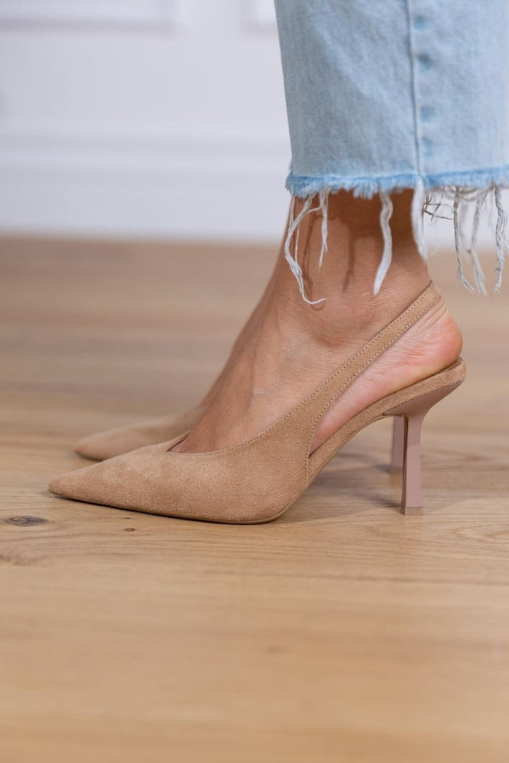 Close-up of tan suede slingback pump with slim stiletto heel