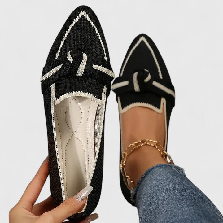 Black knit pointed-toe loafers with white stitching and knot trim