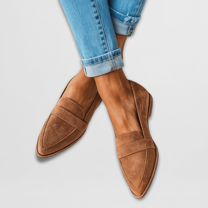 Cognac brown suede pointed-toe loafers worn with cuffed jeans, penny strap detail