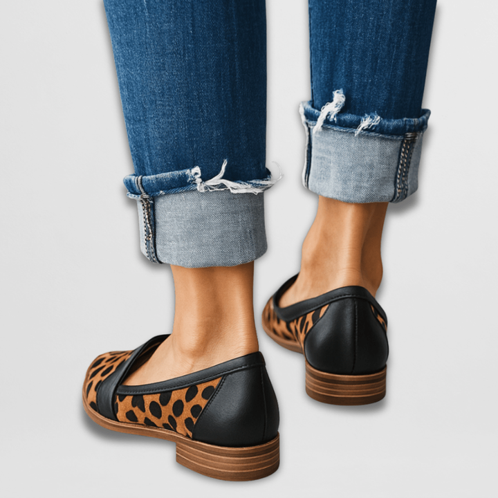 Leopard print loafers with black heel counter, back view with cuffed denim