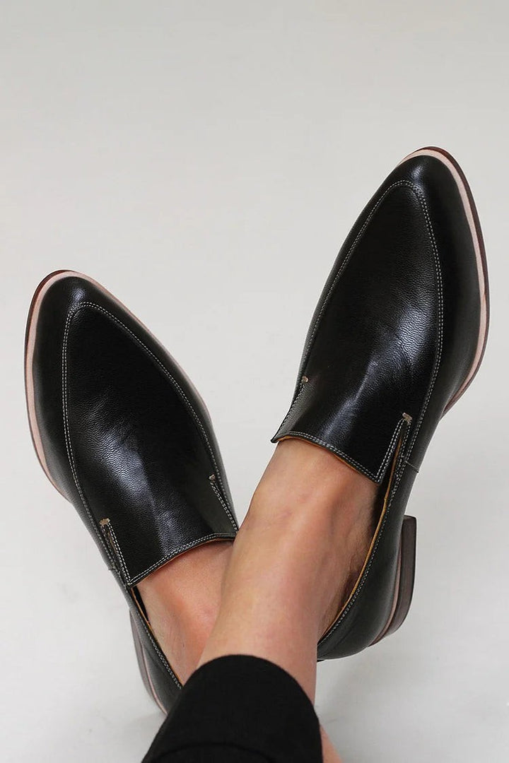 Black leather pointed-toe loafers with contrast stitching and slip-on design