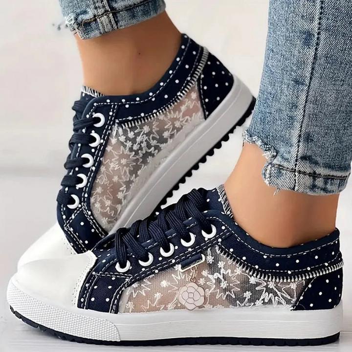 Navy polka dot canvas sneakers with zipper trim and gold ankle chain