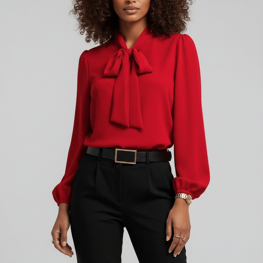 Red bow-tie neck blouse with billowy long sleeves paired with black trousers