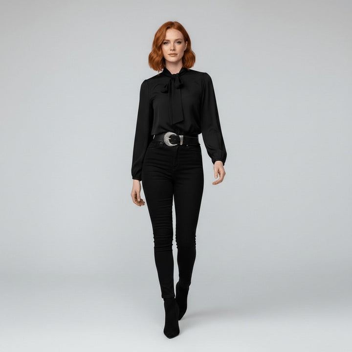 Full-length view of black tie-neck blouse with western belt and black jeans