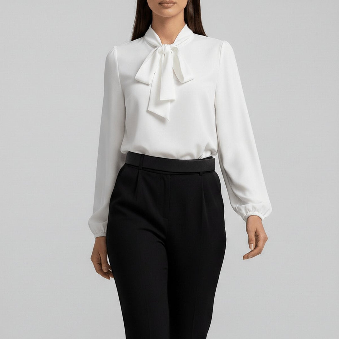 Ivory bow-tie neck blouse with long sleeves worn with black pleated trousers