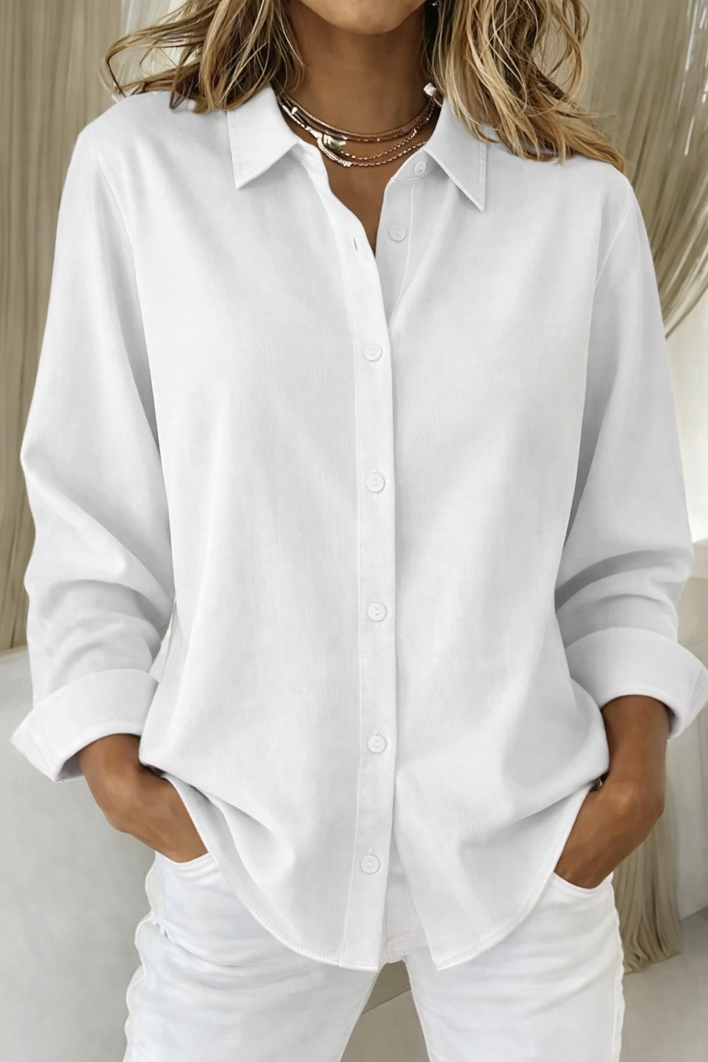 White collared button-down blouse with relaxed fit and folded cuffs