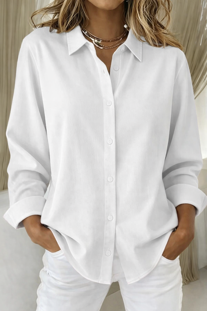White collared button-down blouse with relaxed fit and folded cuffs