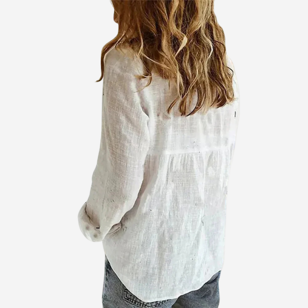 back view of white linen blouse showing roll-tab sleeves and relaxed fit