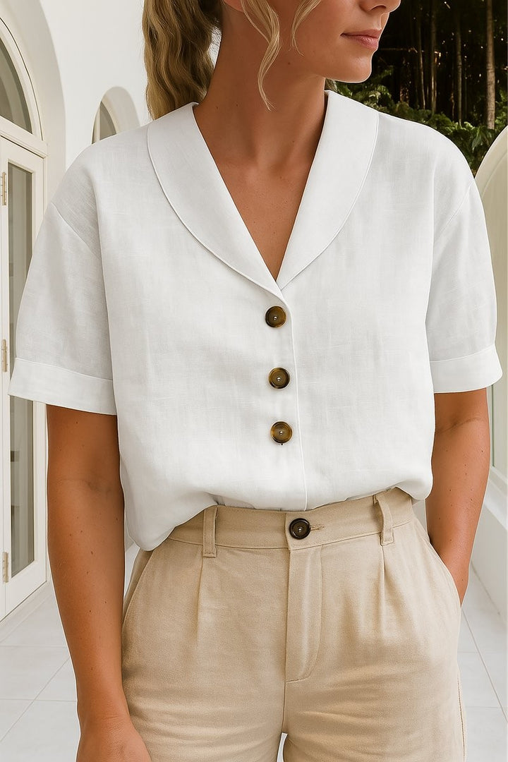 white linen button-front blouse with shawl collar and short sleeves, paired with beige trousers
