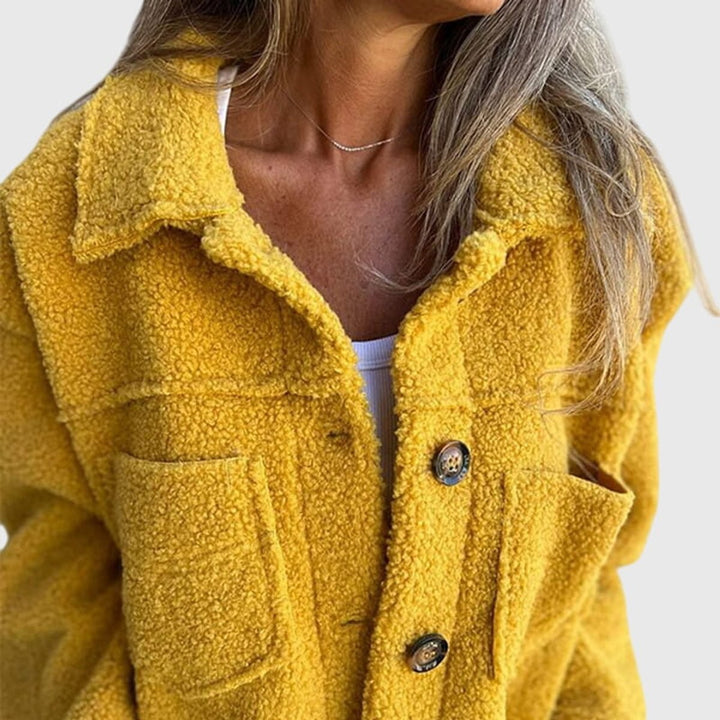 Close-up of mustard yellow sherpa fleece coat collar and button fastening