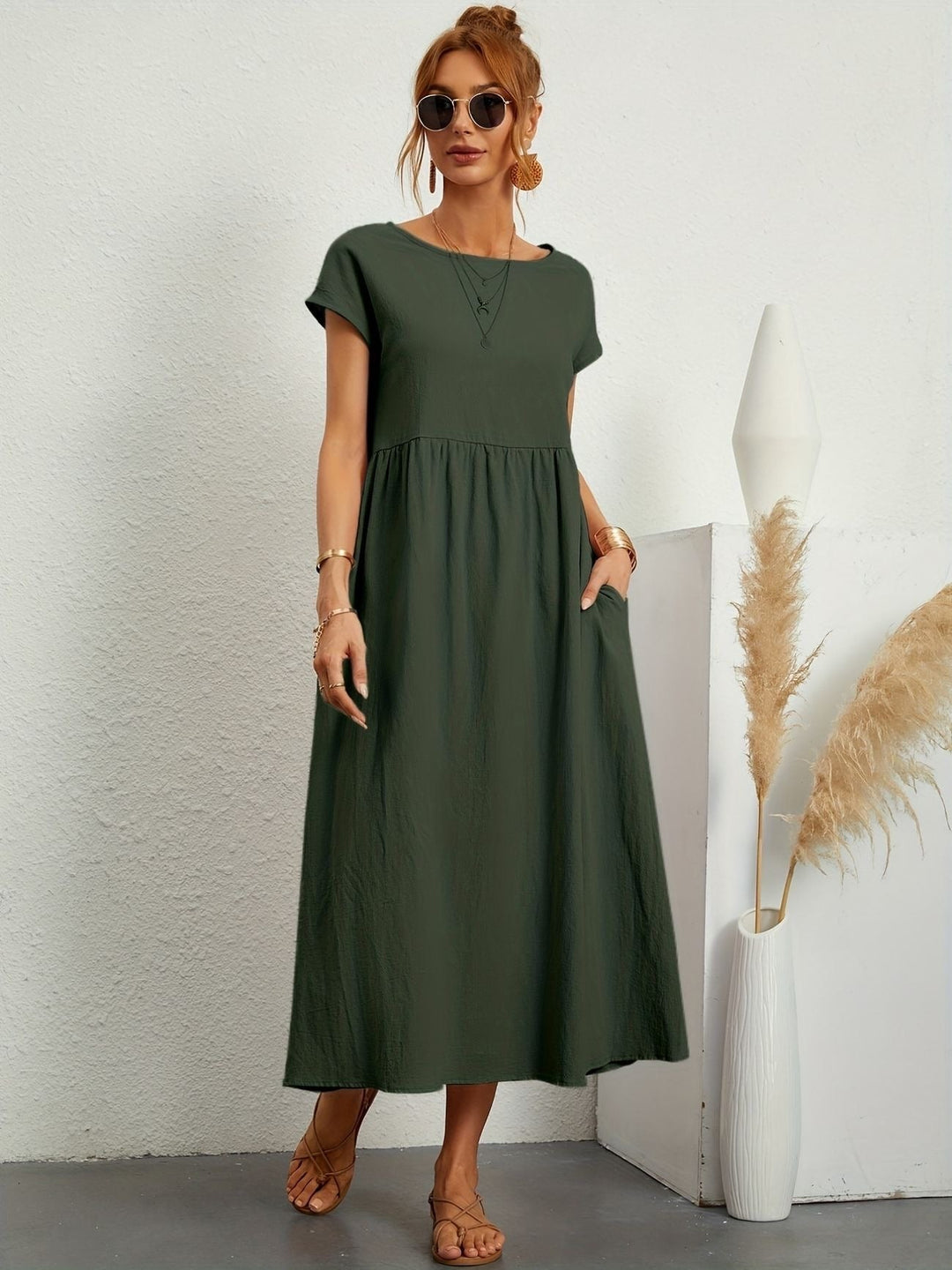 Khaki green cotton midi dress with cap sleeves and side pockets, worn casually