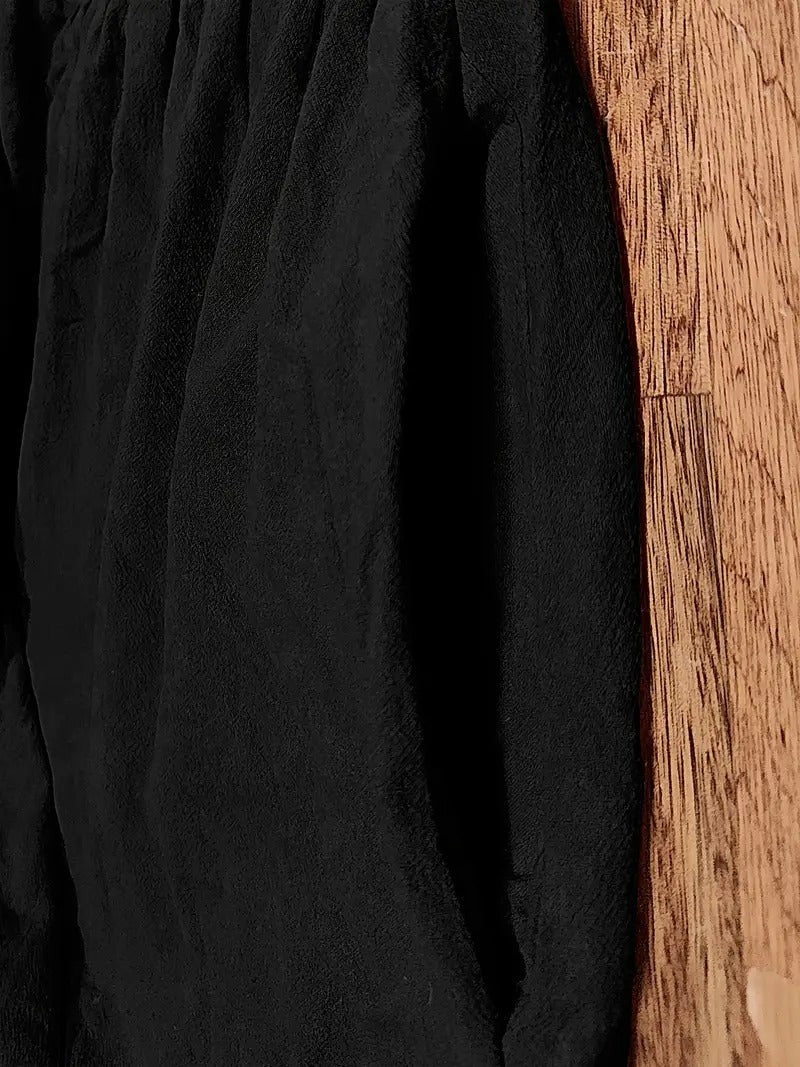 Close-up of black textured fabric folds showing lightweight cotton drape