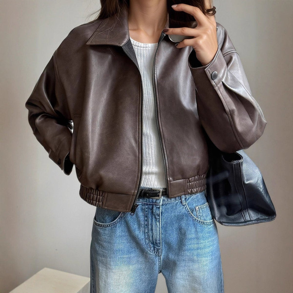 Cropped brown faux leather jacket styled with white top and denim jeans