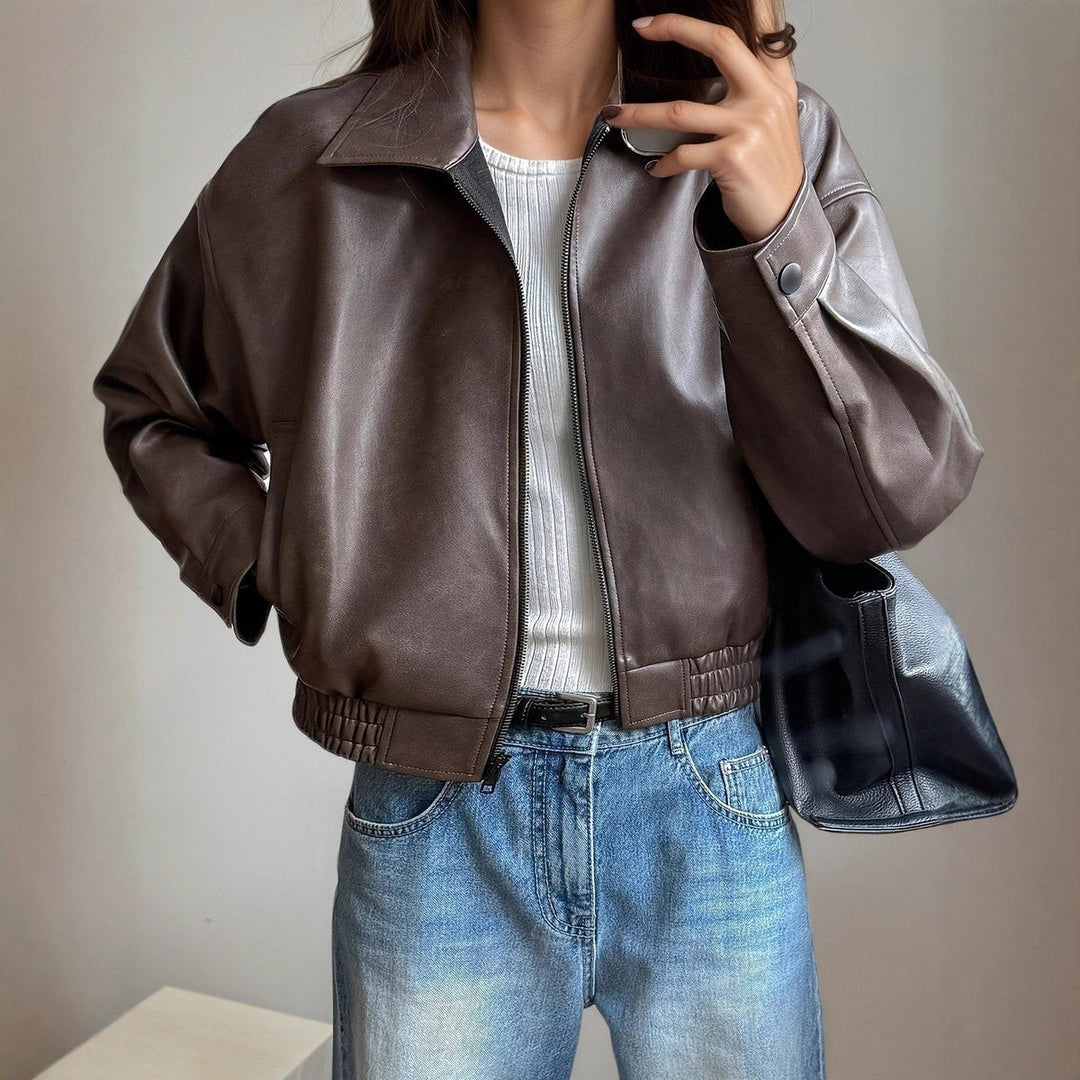 Cropped brown faux leather jacket styled with white top and denim jeans