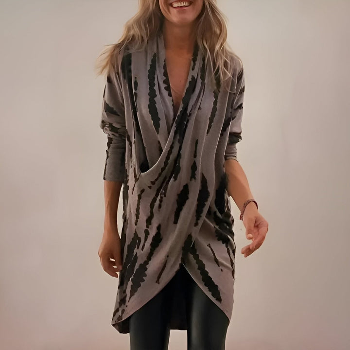 Draped wrap tunic in gray abstract print with plunging V-neckline and long sleeves