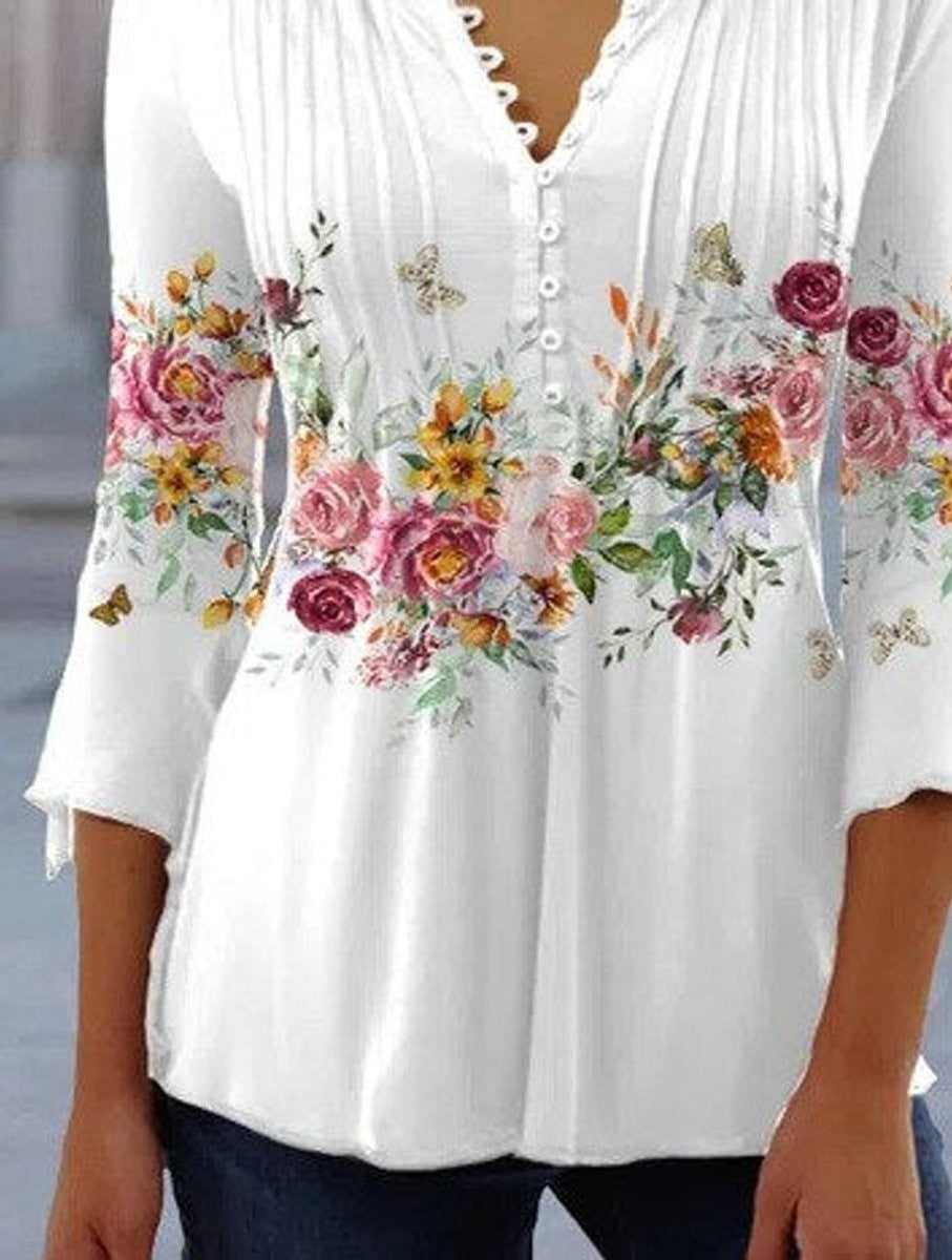 White long-sleeve floral henley top with bell sleeves and pintuck detail