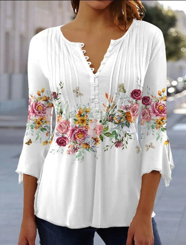 Woman modeling white floral henley blouse with three-quarter bell sleeves