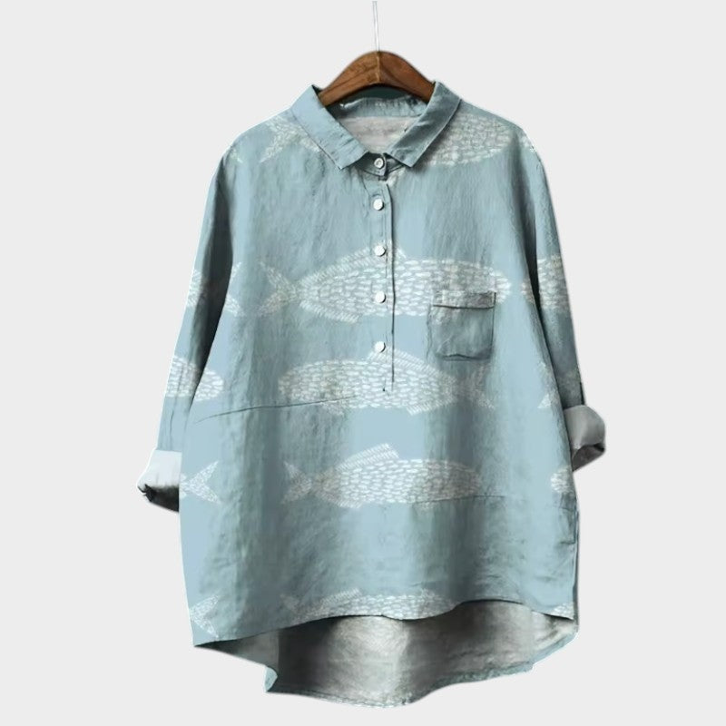 Sage green button-front blouse with a repeating white fish silhouette pattern