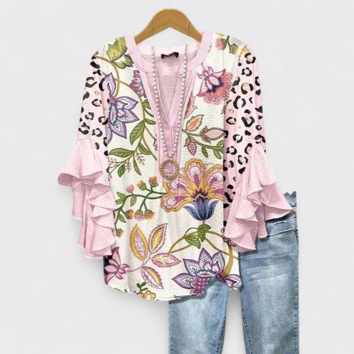 Pink floral blouse featuring leopard print sleeves and ruffle trim