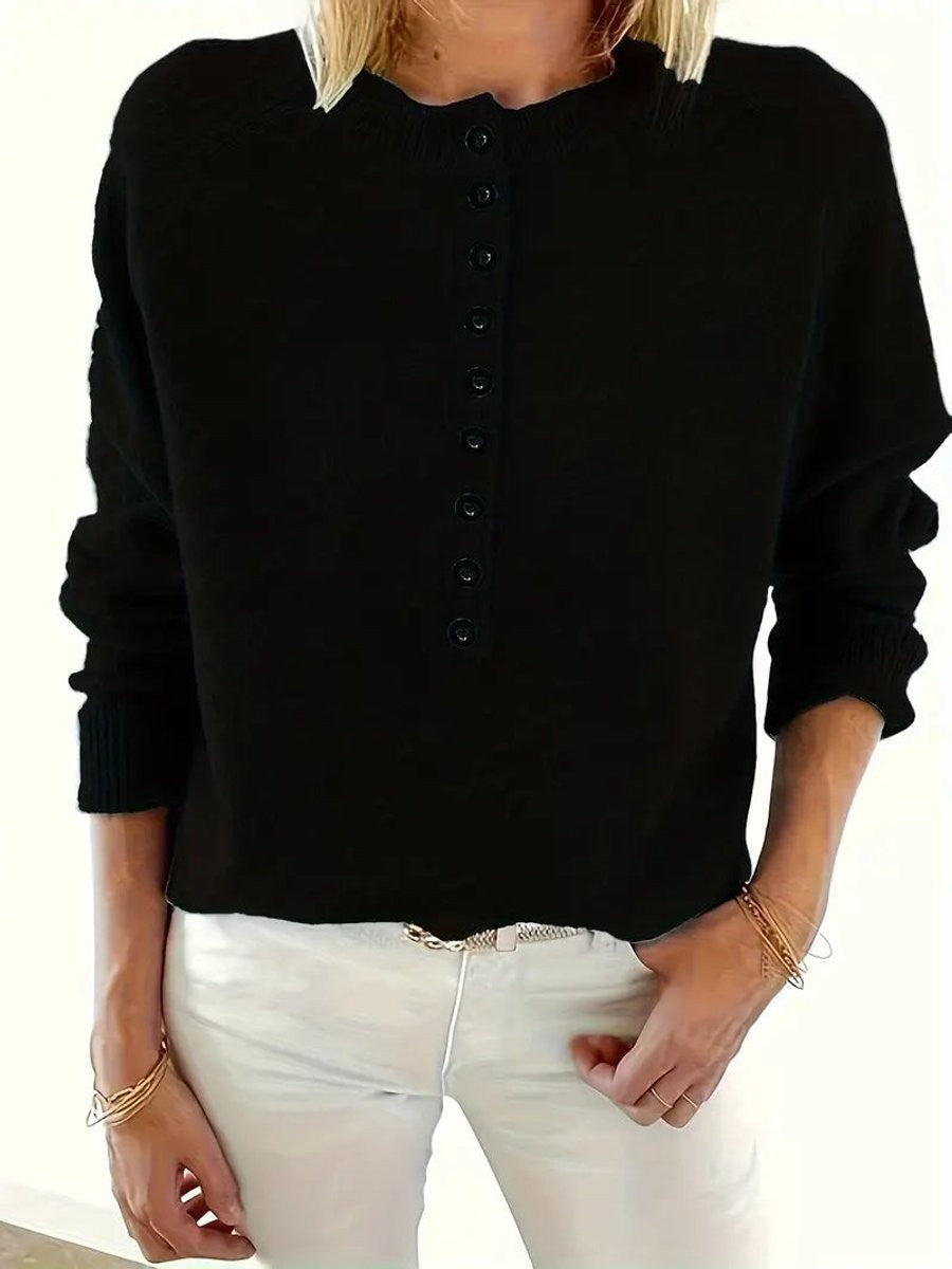 Close-up of black half-button knit jumper with ribbed cuffs and hem