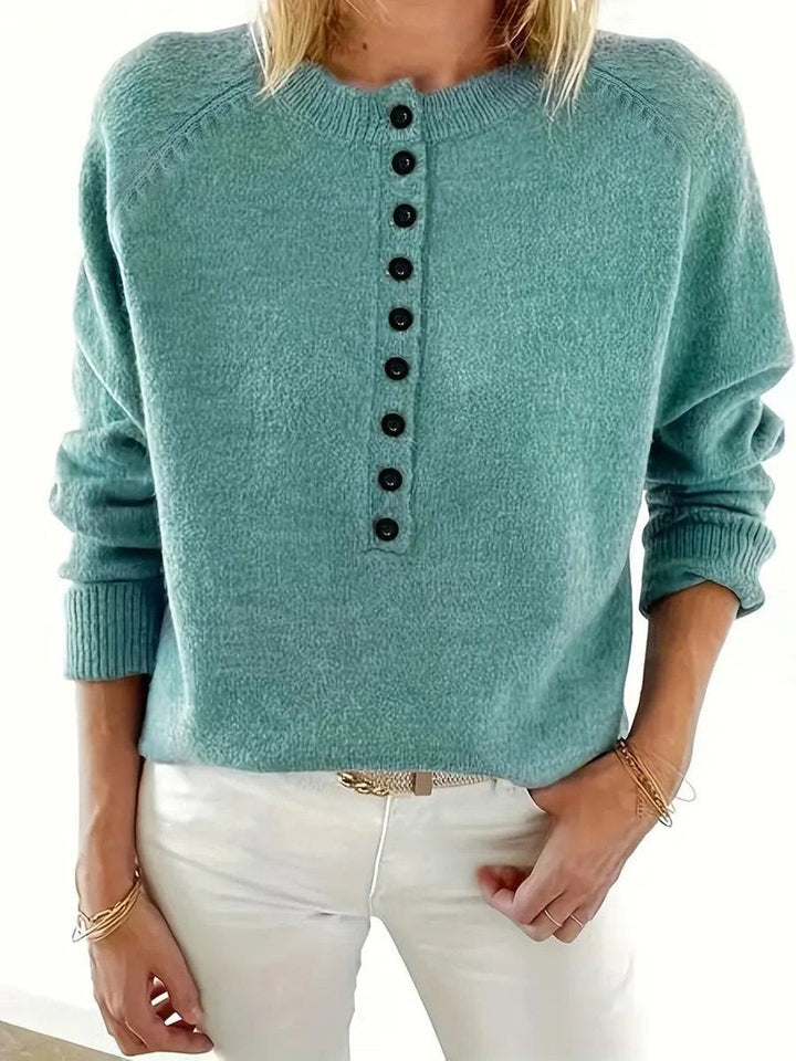 Close-up of sage green half-button knit jumper with ribbed cuffs