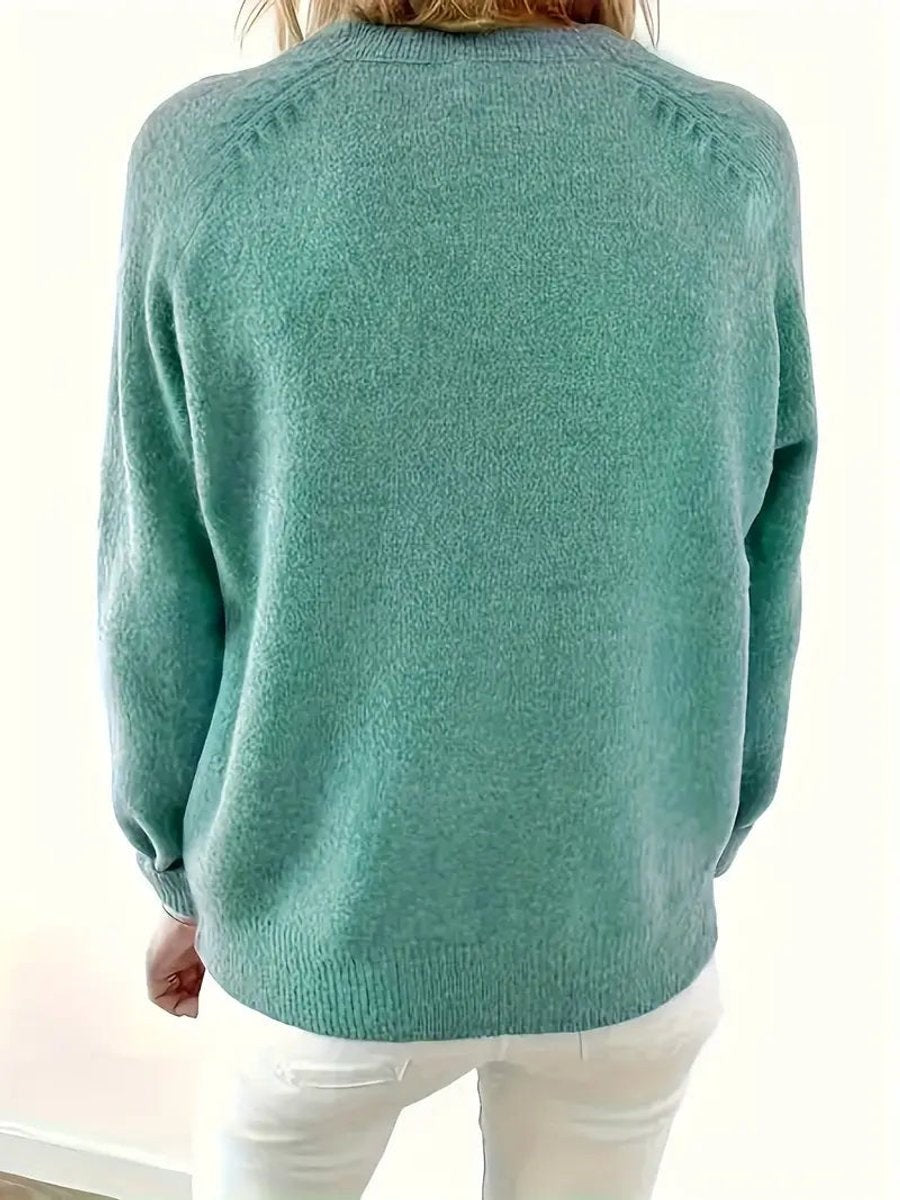 Back view of sage green knit jumper showing relaxed raglan-sleeve fit
