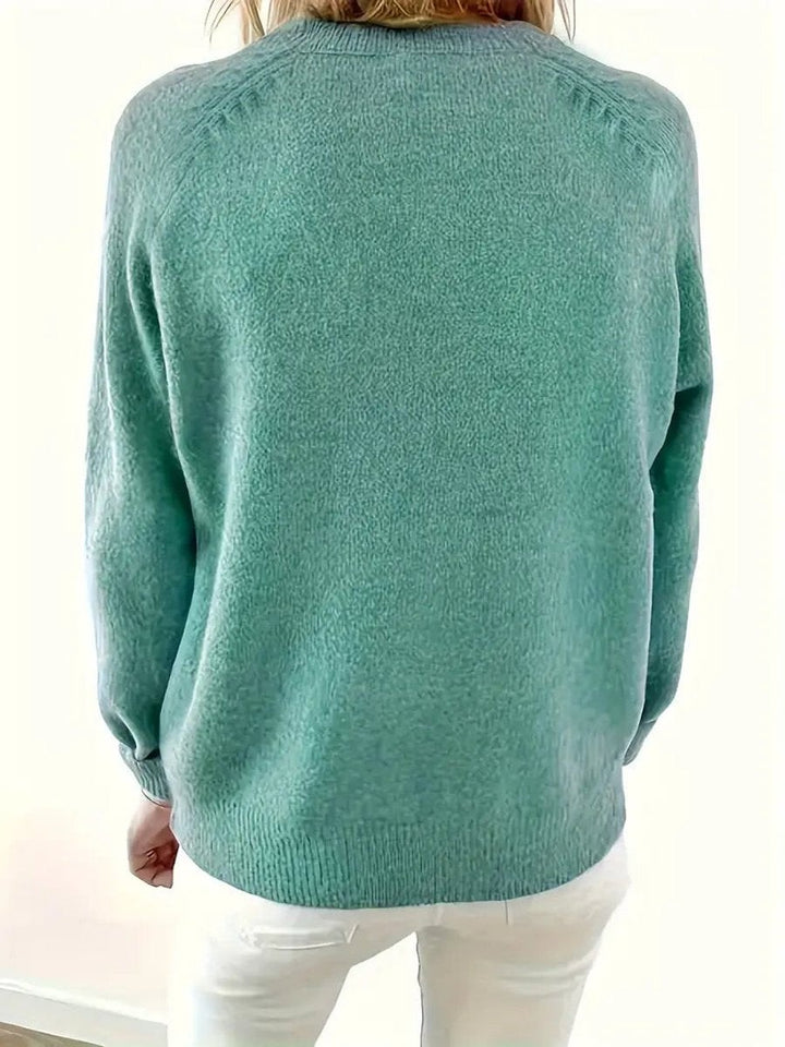 Back view of sage green knit jumper showing relaxed raglan-sleeve fit