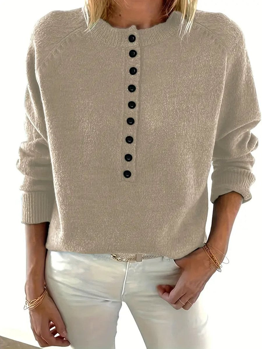 Close-up of beige half-button knit jumper with contrasting black buttons