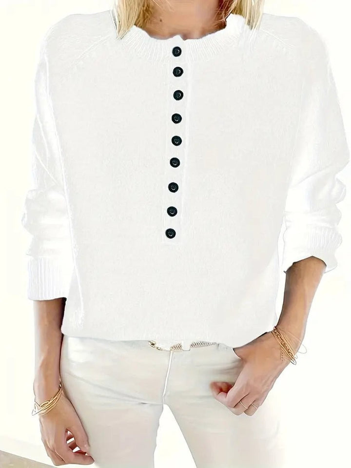Close-up of white half-button knit jumper with ribbed neckline