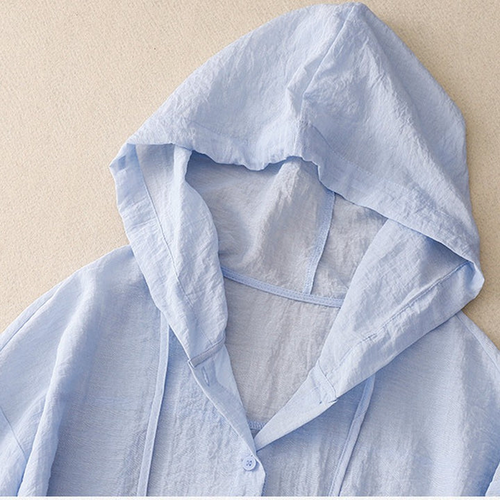 Light blue linen hoodie close-up showing hood and drawstring buttons