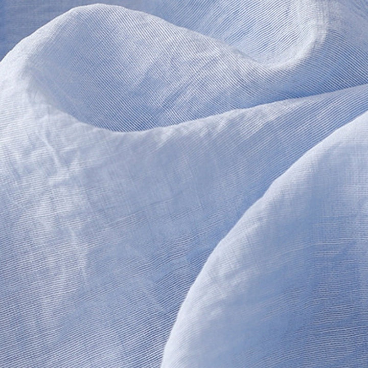 Close-up of light blue linen fabric texture with soft crinkled weave