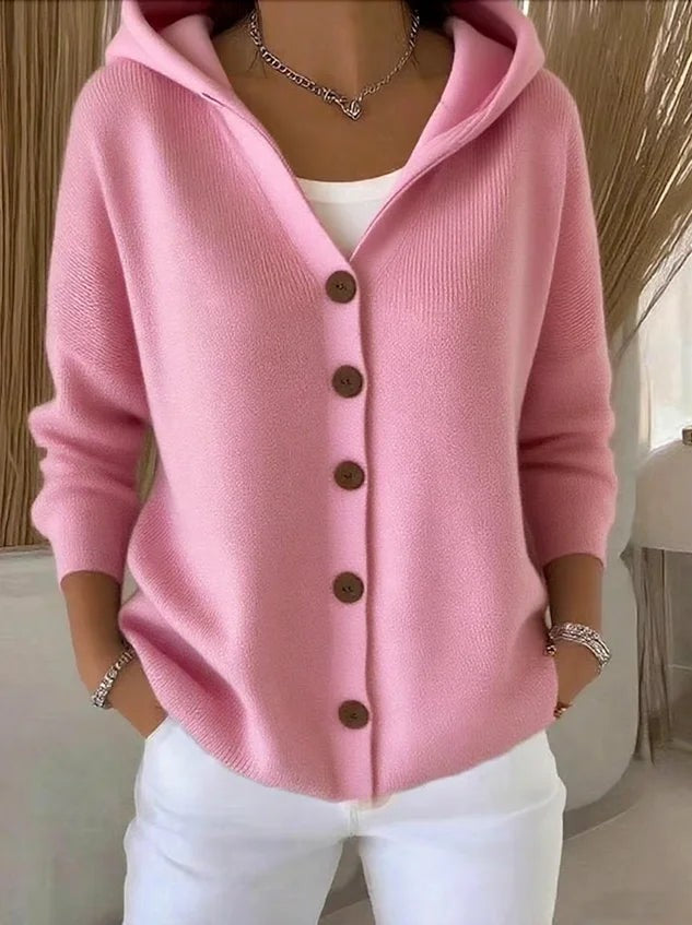 Pink knitted hooded cardigan with brown button-front fastening, styled with white jeans