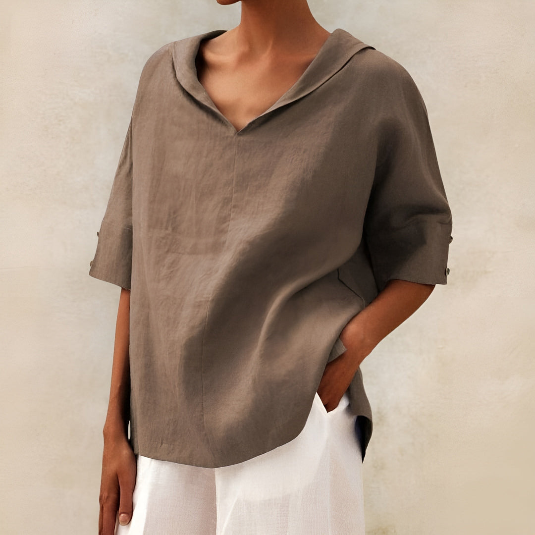 Taupe V-neck blouse showing relaxed drape and rolled sleeves