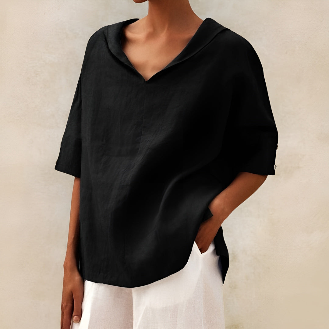Black oversized blouse with V-neck collar paired with white pants