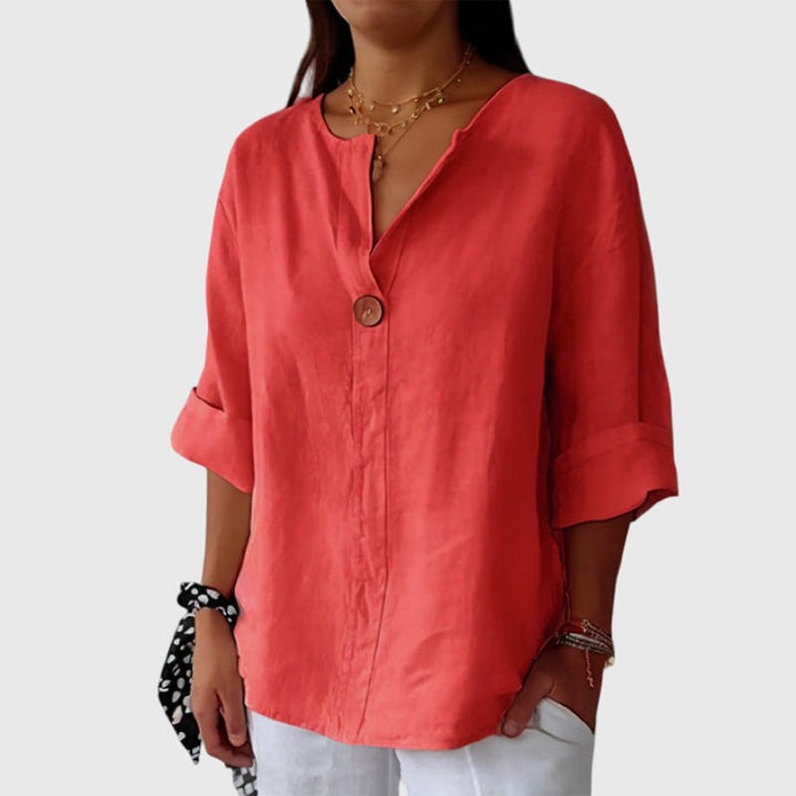 coral V-neck blouse with single button and rolled three-quarter sleeves