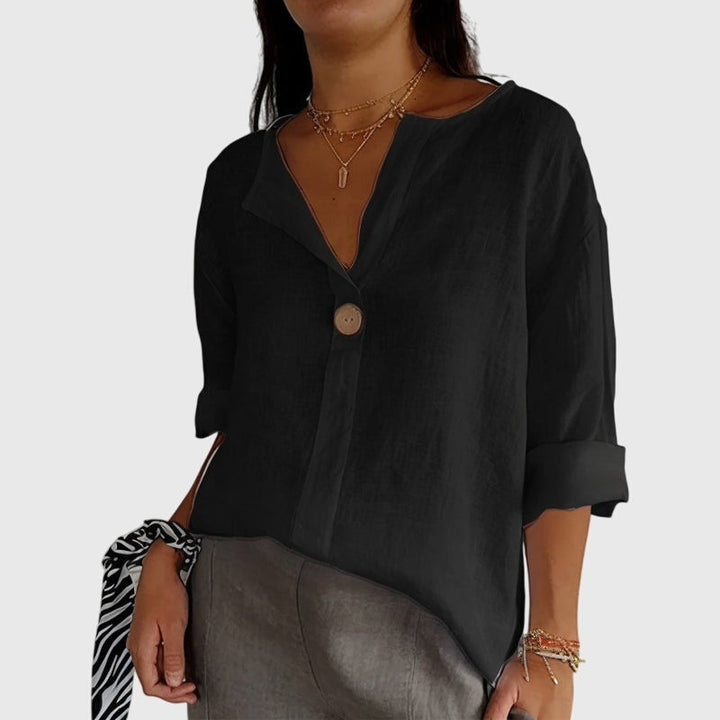 black loose-fit blouse with notched collar and cuffed sleeves