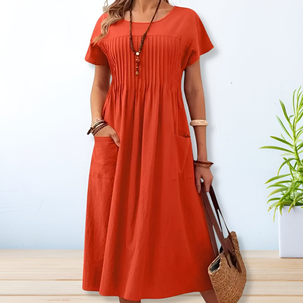 Rust orange pleated midi dress featuring short sleeves and front pockets