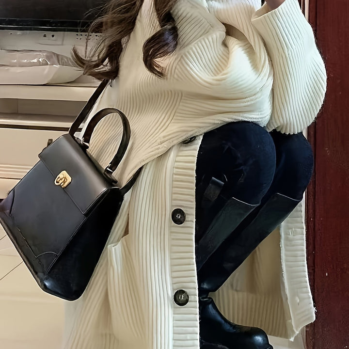 Cream ribbed knit cardigan styled with black boots and handbag