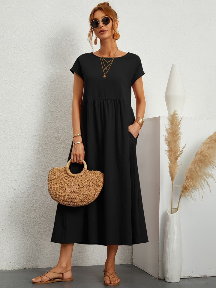 black cap-sleeve maxi dress styled with straw handbag and sandals