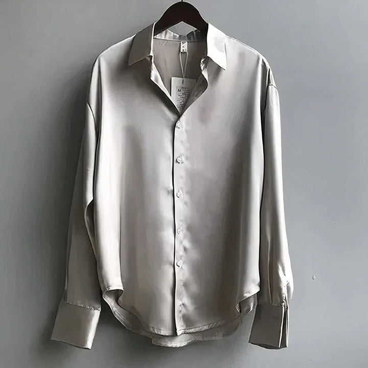Champagne satin button-down blouse with collar hanging on display