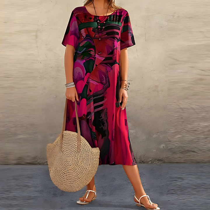 pink and burgundy abstract print midi dress paired with straw tote bag