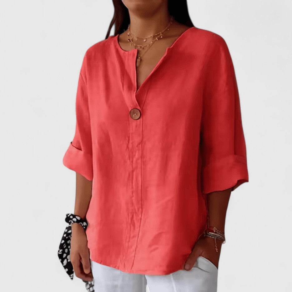 Coral V-neck blouse featuring rolled sleeves and single button detail