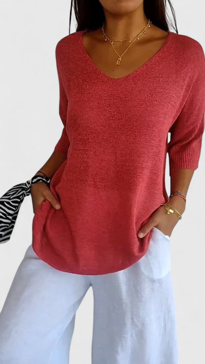 Coral pink V-neck sweater with three-quarter sleeves, relaxed knit fit