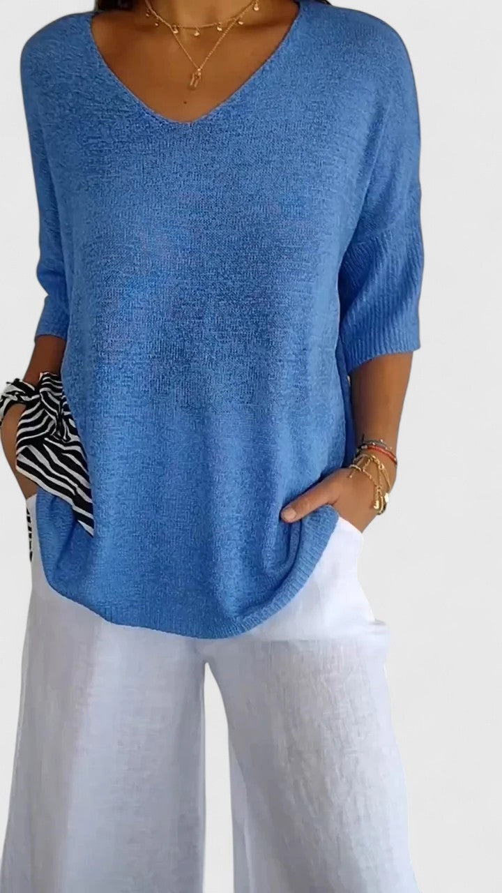 Sky blue V-neck knit top with three-quarter sleeves and curved hem