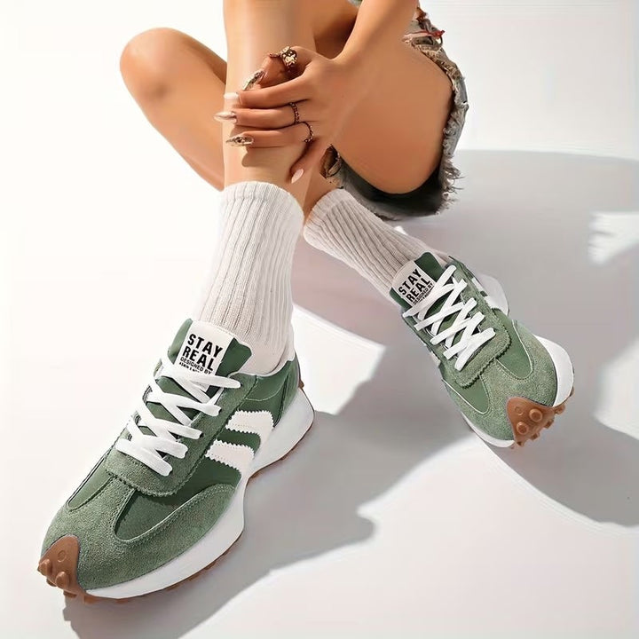 Sage green chunky sneakers with white stripes worn with ribbed white socks