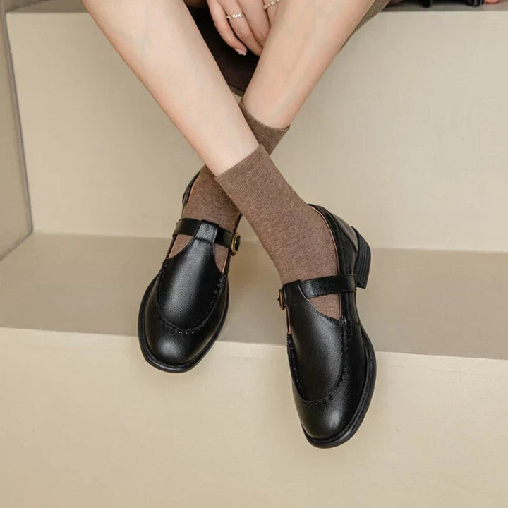 Black leather Mary Jane shoes with gold buckle worn with brown crew socks