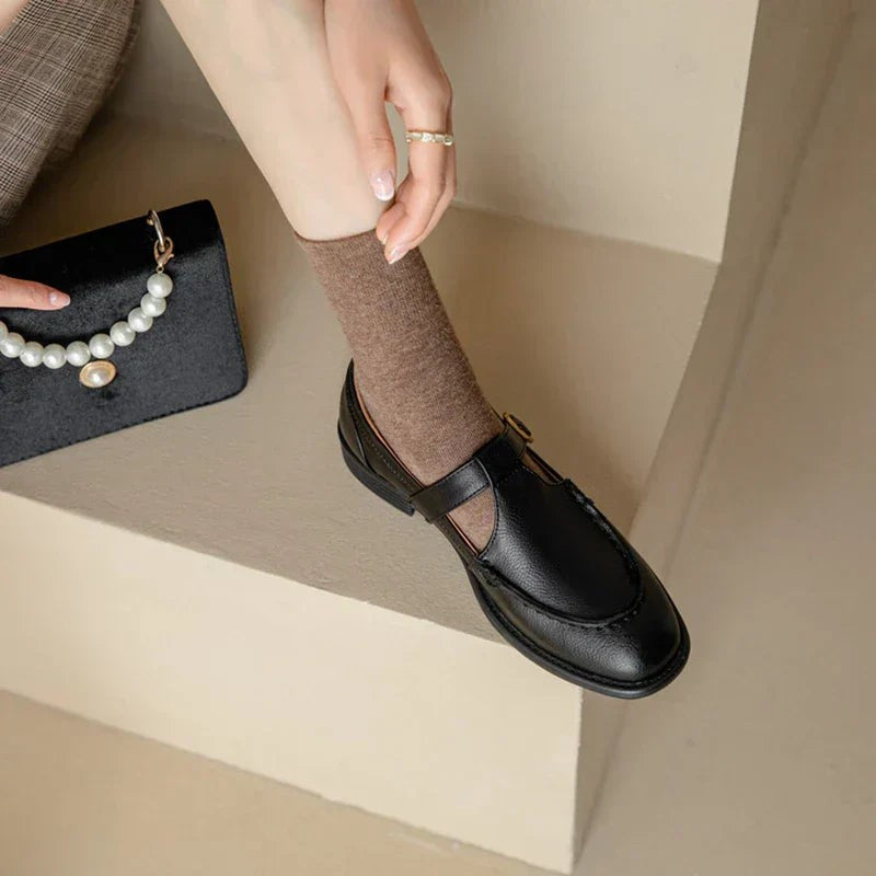 Round toe T-strap Mary Janes in black leather paired with a mini handbag
