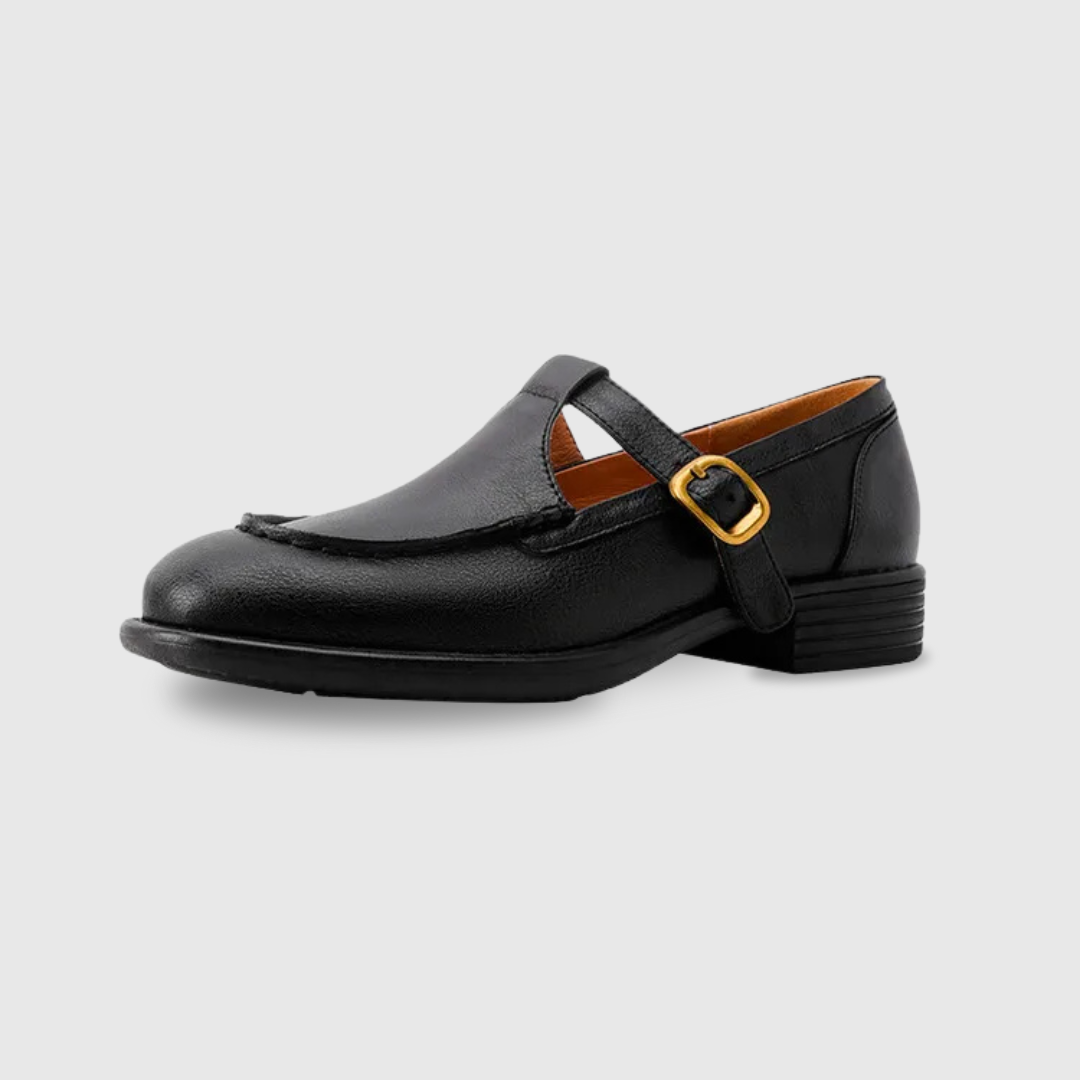 Black T-strap Mary Jane shoe with round toe and gold buckle, side profile view